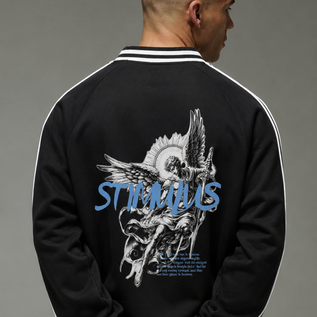 A man viewed from behind wearing a black varsity-style jacket with white stripes on the sleeves and a large graphic print on the back. The print features a white illustrated figure with a blue 'STIMULUS' logo across the center.