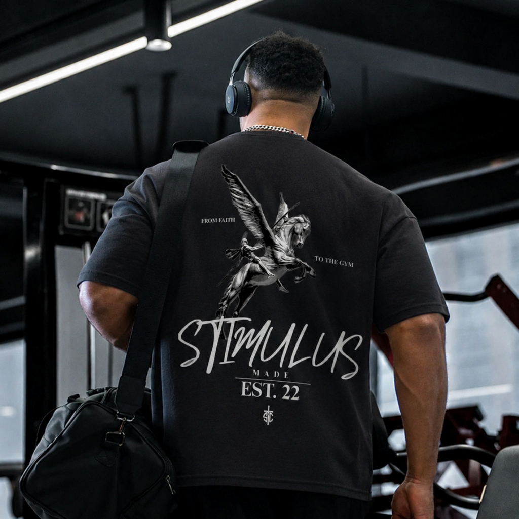 Person wearing a black t-shirt with 'STIMULUS' branding in a gym setting