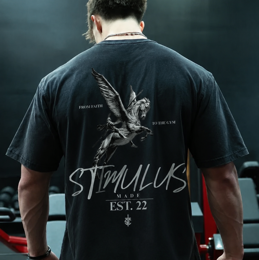 Person wearing a black t-shirt with 'STIMULUS' branding in a gym setting