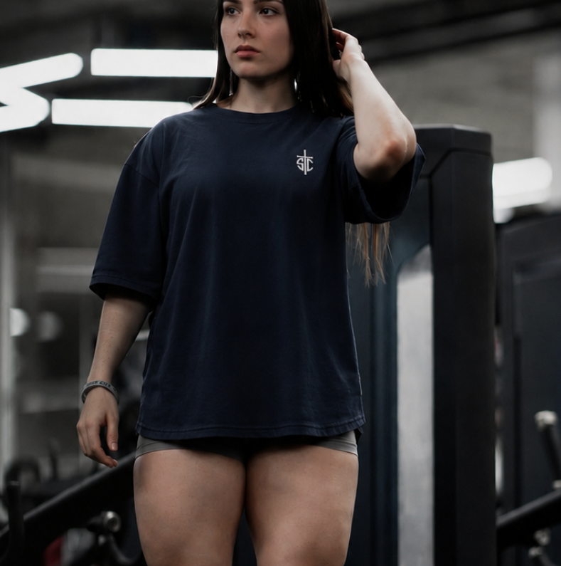 Person in a gym wearing a pegasus Over size t-shirt  with a hexagonal light fixture in the background