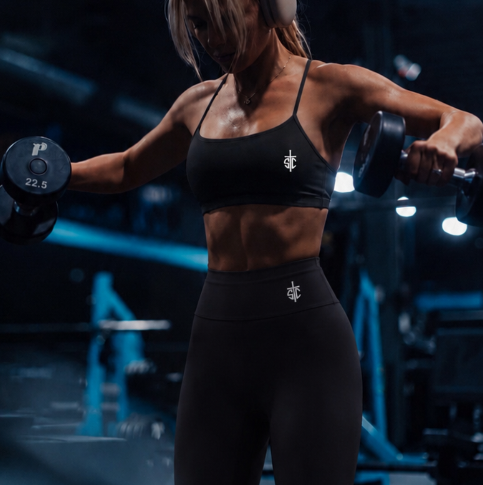 Person lifting weights in a gym setting with blue lighting