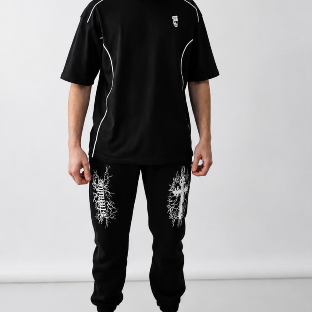 Person wearing a black outfit with white accents against a white background