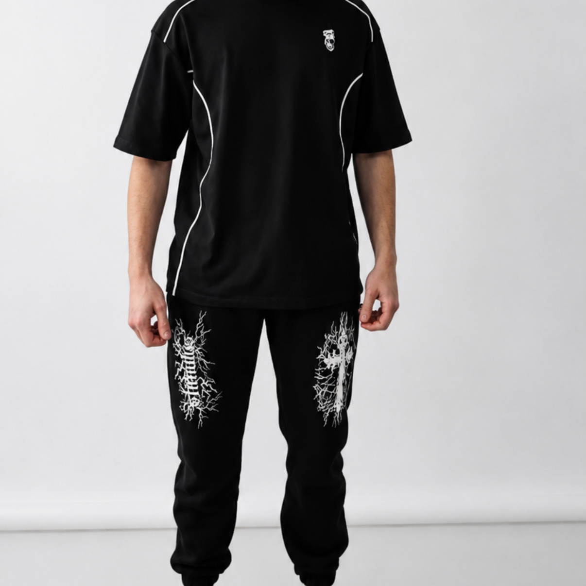 Person wearing a black outfit with white accents against a white background