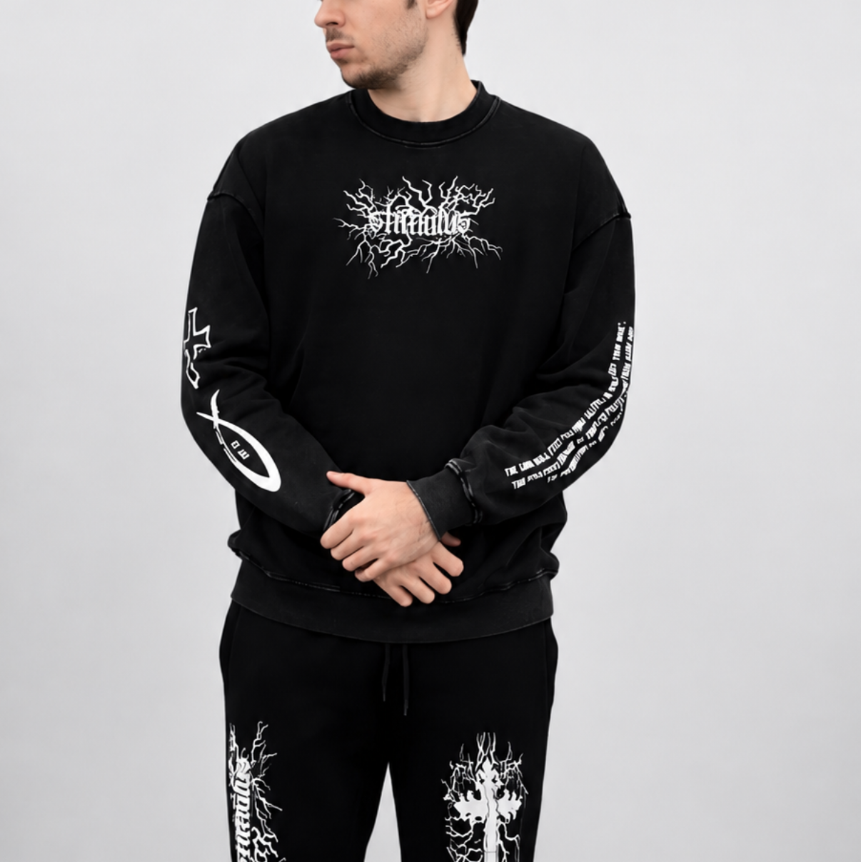 Person wearing a black outfit with white designs against a white background