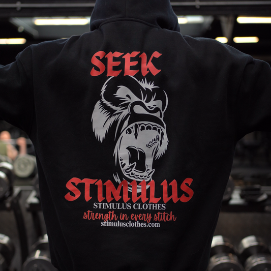 Black hoodie with 'Seek Stimulus' graphic design in a gym setting