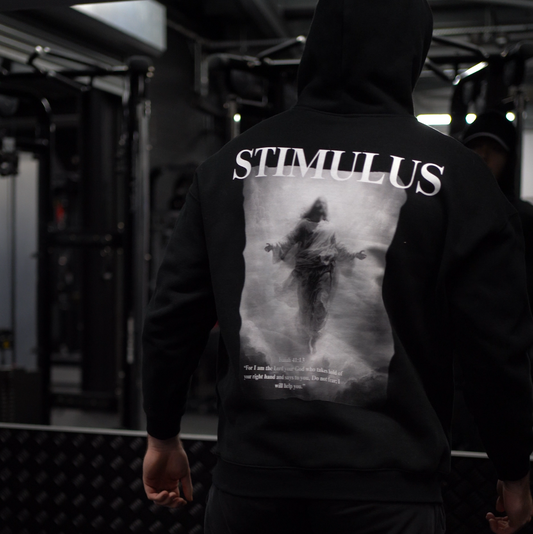 Person wearing a hoodie with 'STIMULUS' branding in a dark setting