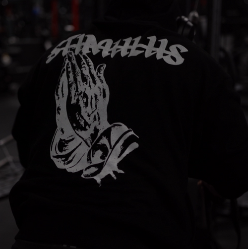 Person wearing a hoodie with 'STIMULUS' logo in a dark setting