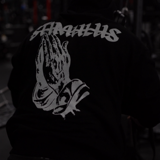 Person wearing a hoodie with 'STIMULUS' logo in a dark setting