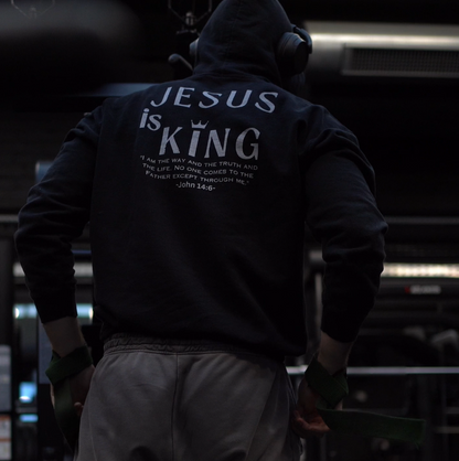 Person wearing a hoodie with 'Jesus is King' text in a gym setting