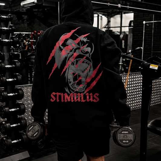 Person wearing a hoodie with a gorilla design and 'Stimulus' text in a gym setting
